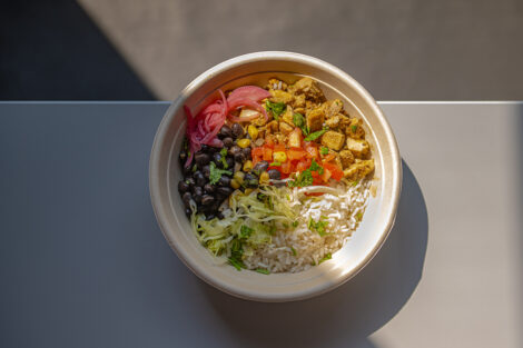 A bowl from Cinco is shown with veggies, rice, and chicken.