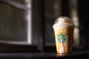 A Starbucks beverage is shown with whipped cream and caramel