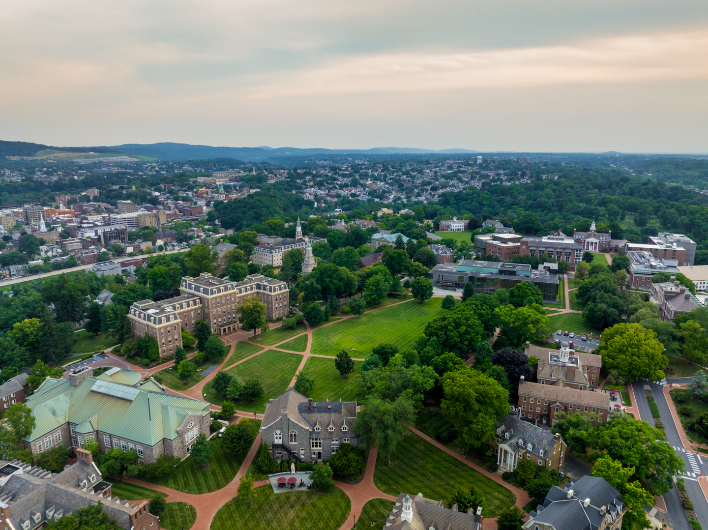 An aerial view of Lafayette college's quad. The top 25% of the frame is and early evening sky. The city of Easton Pa and it's West Ward can be seen in the background. 