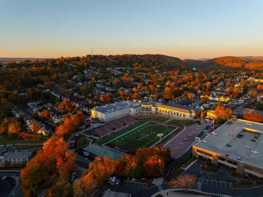 Aerial view of Fisher Stadium surrounded by fall foliage.