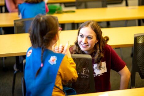 A Lafayette engineering student works with a young Daisy scout during Girl Scout Badge Day.