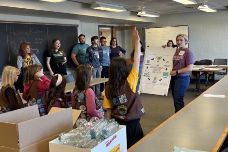 Dean Lauren Anderson shows a poster illustrating the engineering cycle to Girl Scouts during the first Girl Scout badge day.