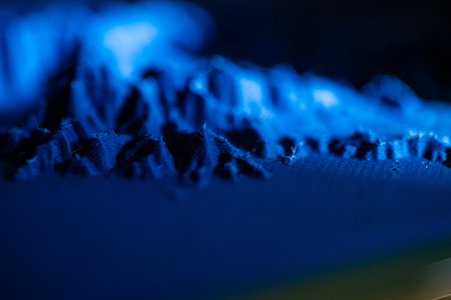 Close look at a 3D printed geological survey model glowing in blue light. 