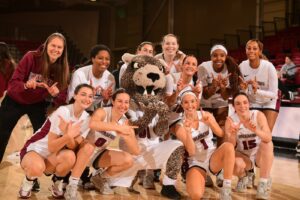 The women's basketball team poses on the court with the Leopard