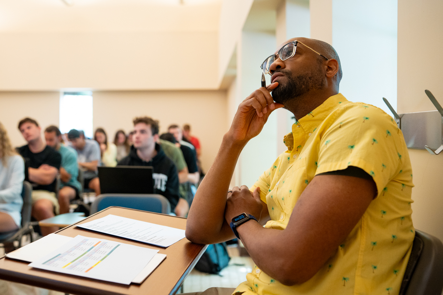 Jaison Freeman and his class attentively watching student presentations on athletes and mental health projects.
