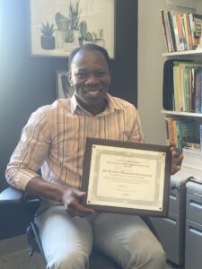 A photo of Ernest holding his plaque