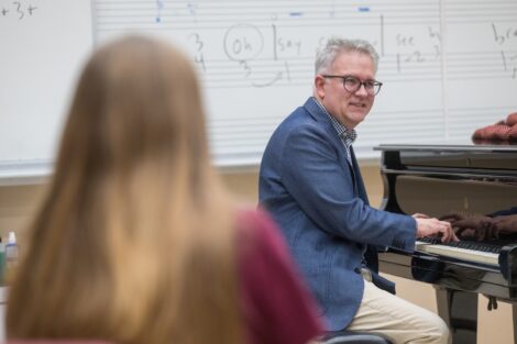 Ian Moschenross, visiting professor- music, plays the piano in class.