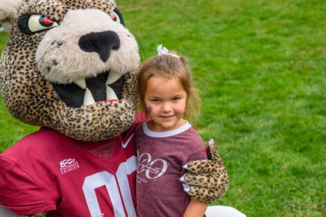 Roary the Leopard greets a young fan at the La Fête Lafayette Tailgate.