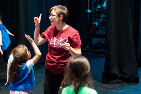 Prof Courtney Ryan holds one finger in the air as she gestures to a group of Daisy scouts.