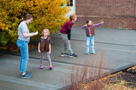 Two Girl Scout Brownies are shown with two Lafayette volunteers as they launch their fling fliers in the air.