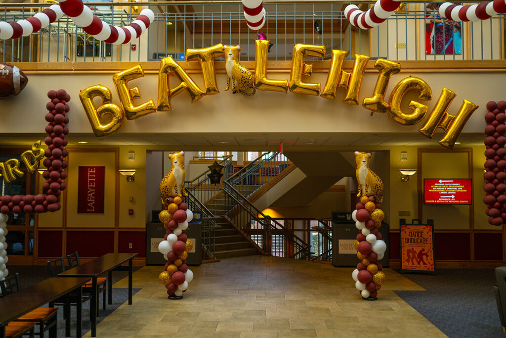 An interior shot of Farinon shows gold balloons reading Beat Lehigh, adorned with maroon, white, and gold balloon columns.