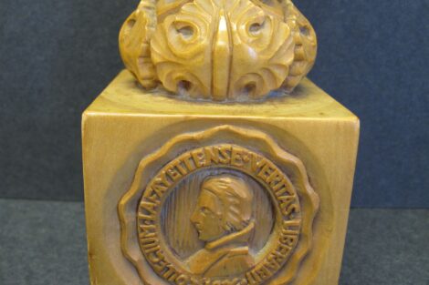 The photo of the Lafayette College mace shows the College seal and coat of arms of the Marquis de Lafayette. A detailed shot of the base of the mace is shown.