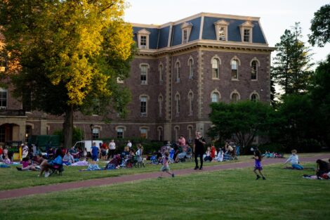People sit in chairs and blankets on the Quad in front of Pardee as they wait for the movie to begin.