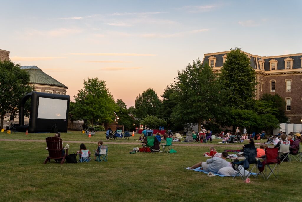 The sun begins to set on the Quad as people gather to watch Movies on the Quad.